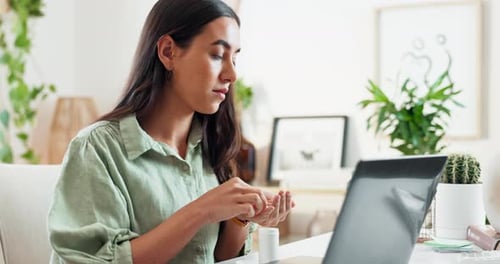 Young Woman Taking Pills at Desk