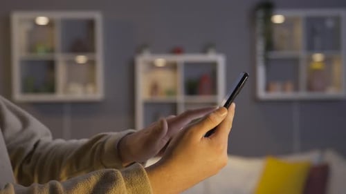 Hands Use Smartphone in Relaxing Home Setting