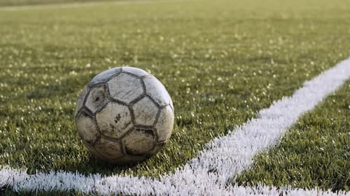 Old Gray Soccer Ball Lies in Corner of White Lines Football Pitch