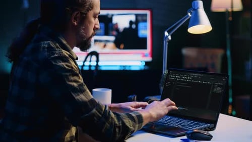 Programmierer schreibt Code auf den Laptop-Bildschirm, während er im Büro einer Wohnung mit Java ist