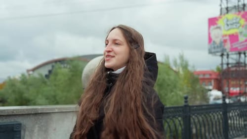 Vibrant Young Woman with Flowing Hair on Bridge Photographs Cheerful Scene Enthusiastic Woman with