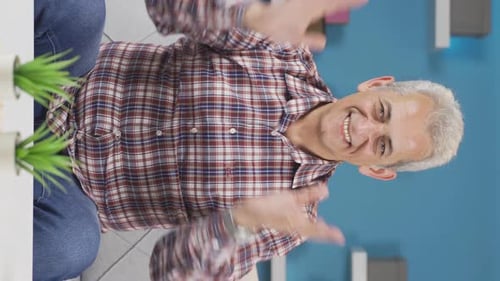 Vertical video of Man experiencing joy looking at camera.
