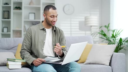 Young Man Video Chatting and Working at Home