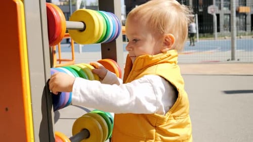 Porträt eines kleinen Jungen, der auf dem Spielplatz mit buntem Abakus spielt