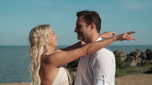 A Man and Woman in Love Hugging While Standing on the Ocean During Their Honeymoon