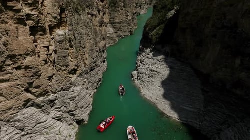 A Landscape Filled with Mountains A Group of Tourists on Several Boats Floats on Green Water Aerial