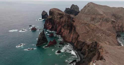 Aerial shot of rugged red cliffs and a scenic trail along Ponta de São Lourenço on Madeira Island, P