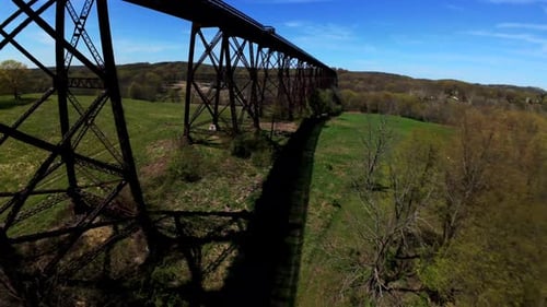 Vista aérea con un Zumbido FPV volando bajo el viaducto de Moodna en Salisbury Mills, Nueva York, en un soleado d