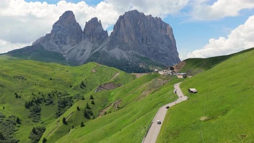 Drone flight over alpine road towards Dolomites peak