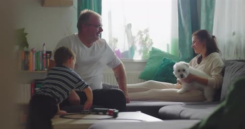 Family Playing with Toy Train at Home with Dog