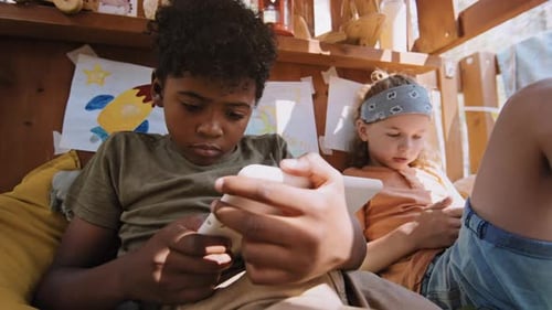Children Relaxing with Tablets in Playhouse