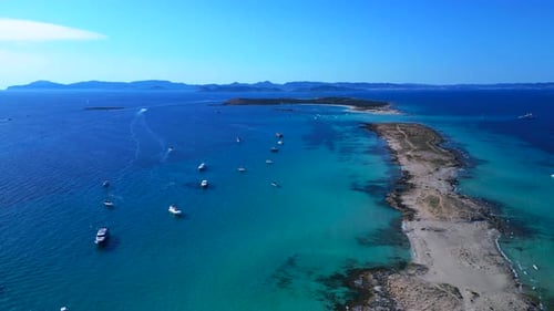 Formentera island coastline, boats on clear turquoise water. Wonderful aerial view drone