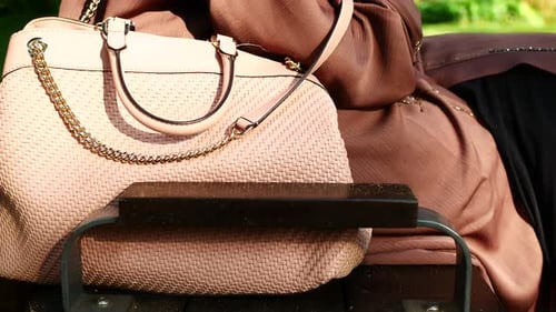 Woman with Designer Handbag on Park Bench