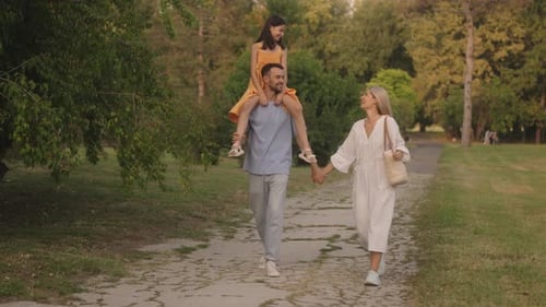 Happy Family Walks in the Park on a Summer Evening