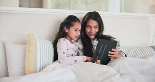 Mother and Child Using Tablet in Bed