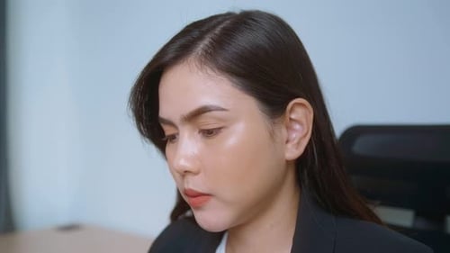 Young Woman Rubbing Temples in Office Close Up