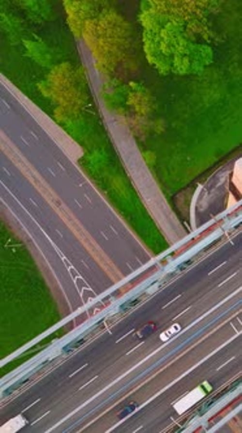 Cars and lorries passing by the lively motorways. Top view on the road junctions in busy metropolis