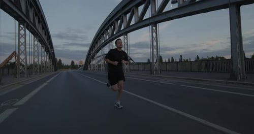 an athlete goes running, jogging on a bridge on the Main in Frankfurt