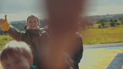 Smiling Children Giving Thumbs Up in Urban Park
