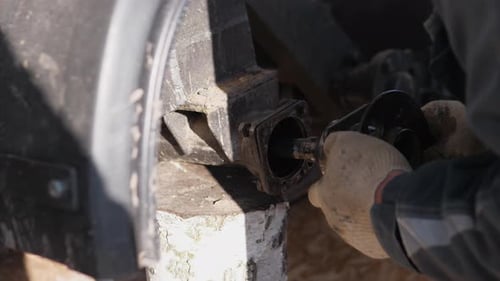 Mechaniker repariert Fahrzeugteile im Freien, Hände, repariert Radlager in staubigen Umgebungen, Arbeiten