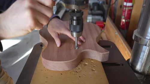 Person Making a Guitar With a Drill Press