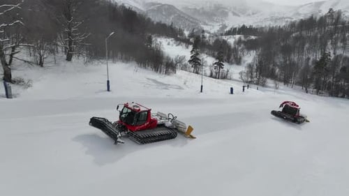 Rote Pistenpräpariermaschinen bereiten die Pisten für Touristen im Bergresort Bakuriani vor