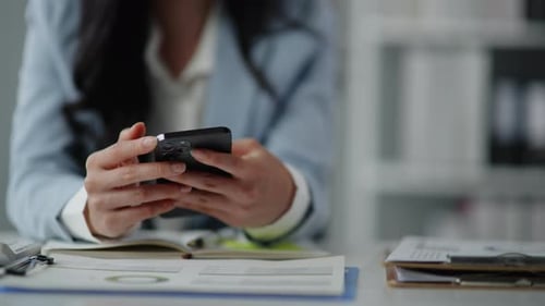 Woman Using Smartphone at Office Desk