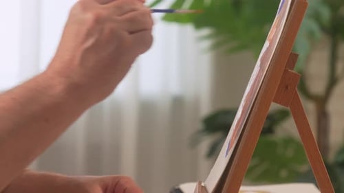 Hand painting on canvas with a paintbrush indoors