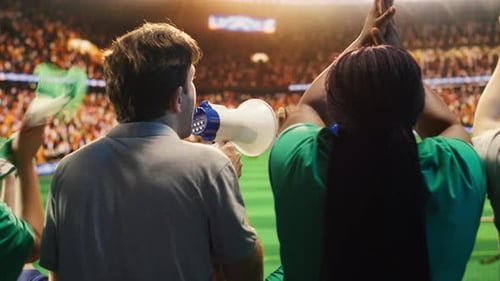 Close Up of Man Yelling Through Megaphone in Soccer Stadium to Cheer Players
