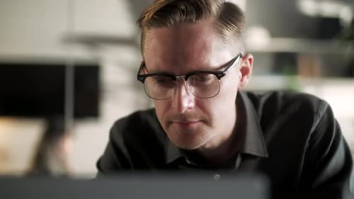 Young Man Freelancer Using Laptop Online Working From Office In Internet Smiling Focused Millennial