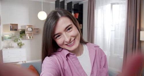 Smiling Woman Talking Directly to Camera in Living Room