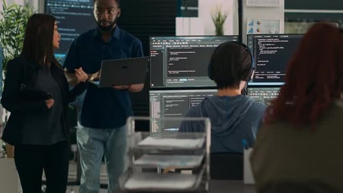 Équipe diversifiée de programmeurs de données analysant la programmation de code sur ordinateur portable