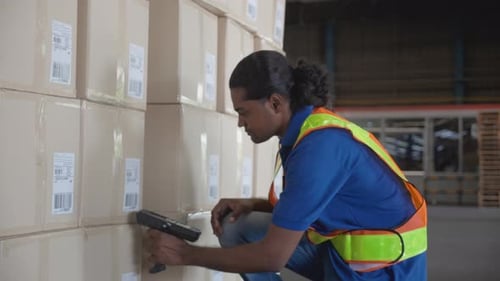 Young man scanning barcode to package box with transportation and distribution in the warehouse.