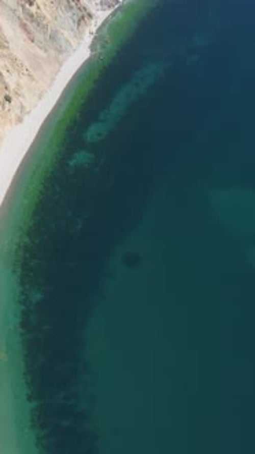 Aerial Vertical View of Seascape with Crystal Clear Calm Azure Sea and Rocky Shores A Beautiful