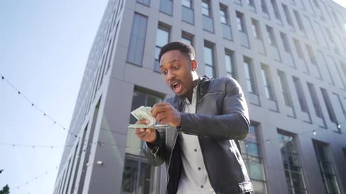 Man Counting Money Outside Modern Urban Building