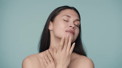 An Attractive Young Woman Runs Her Fingers Across Her Face Gently Touching Smooth Healthy Skin Close