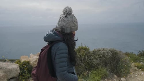 young woman walking on the coastal mediterranean nature with the sea in the background, on the islan