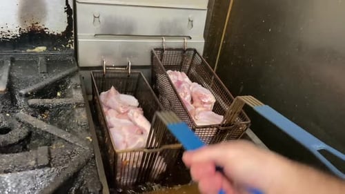 chicken wings fried in oil fryer of restaurant kitchen