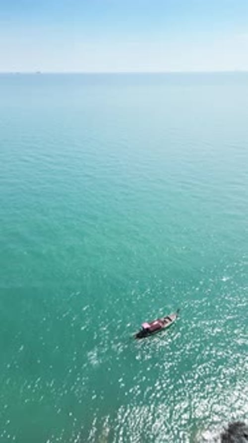 Vertical Video Aerial View of a Sailboat Anchored in a Stunning Turquoise Lagoon
