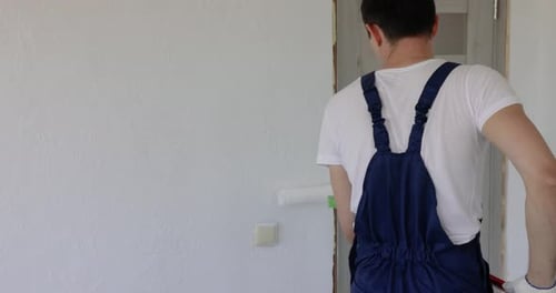 Man Painting Wall in White Color with Roller
