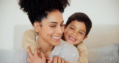 Smiling Woman with Child Hugging Her Indoors