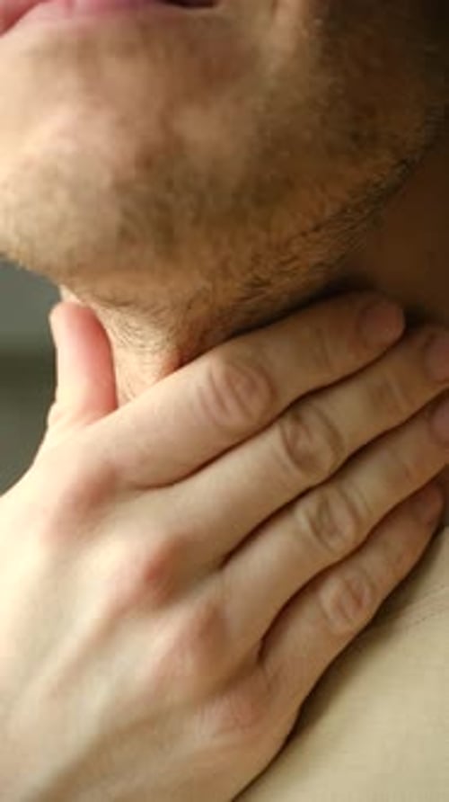 Man with Hand on Throat Feeling Pain