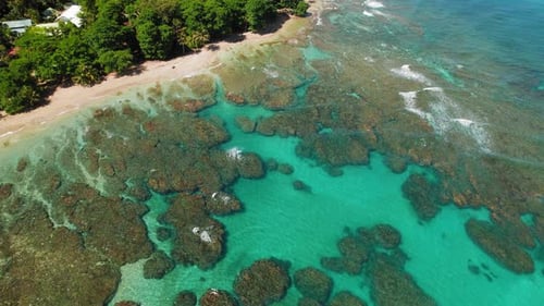 Aerial view of coral reef and sandy beach along Costa Rica coast on a clear warm morning