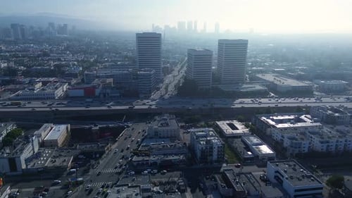 Drone aerial of Los Angeles LA city skyline CBD cars driving over bridge peak hour traffic highway f