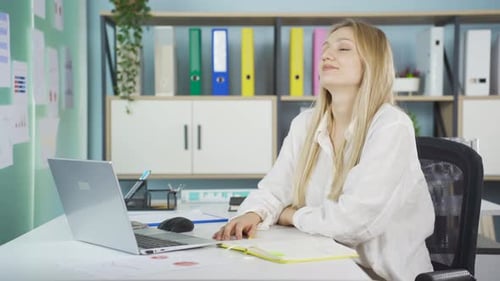 Woman Stretching at Her Desk in Bright Office
