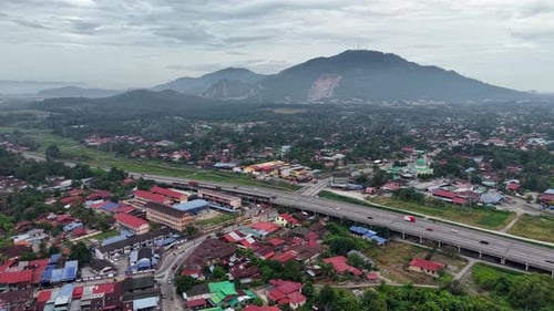 Aerial drone view of Kubang Semang town with highway and hills