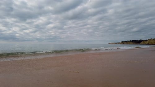 Panoramasicht auf die Atlantik-Brandung an einem Sandstrand.