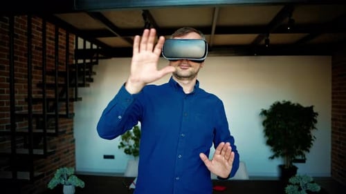 Man gesturing while using a Virtual Reality headset in an office