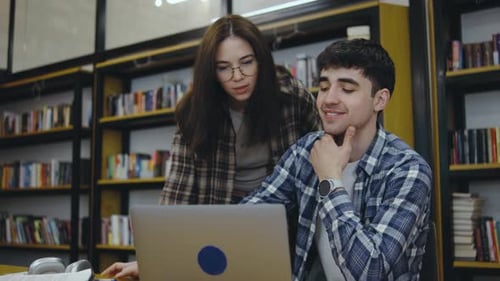 Schüler arbeiten an einem Projekt in einer gemütlichen Bibliothek mit reichlich Bücherregalen und einer entspannten Atmosphäre zusammen