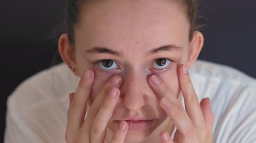 Woman Applying Eye Cream in Close Up